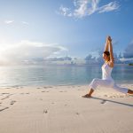 pratica dello yoga sulla spiaggia