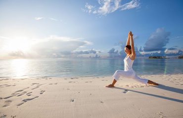 pratica dello yoga sulla spiaggia