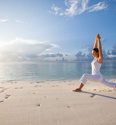 pratica dello yoga sulla spiaggia