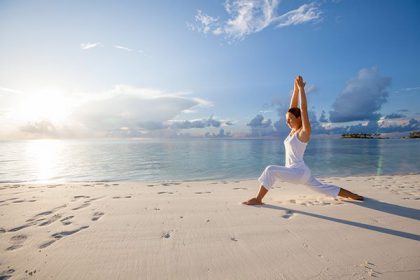 pratica dello yoga sulla spiaggia